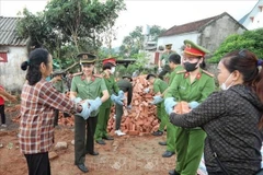 Bac Giang's police officers support the removal of temporary and dilapidated houses for poor and near-poor households in the province. (Photo: VNA)