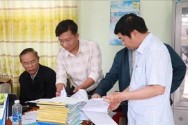 Deputy Minister of Agriculture and Rural Development Phung Duc Tien (first, left) and inspectors examine fishing vessels' daily records at Dong Tac fishing port in Tuy Hoa city, Phu Yen province. (Photo: VNA)