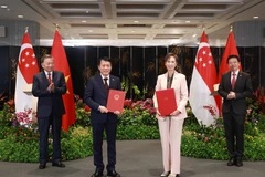 Party General Secretary To Lam (L) and Singaporean PM Lawrence Wong (R) witness the exchange of a MoU on digital transformation between the Vietnamese Ministry of Public Security and the Singaporean Ministry of Digital Development and Information on March 12. (Photo: VNA)