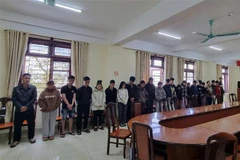 The suspects are caught red-handed while conducting a money laundering transaction on Tu Tao street, Da Lat city, Lam Dong province. (Photo: VNA) 