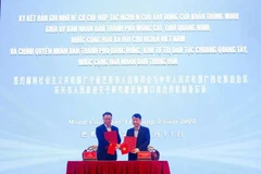 Chairman of the Mong Cai City People's Committee Ho Quang Huy, and Mayor of the Dongxing City People's Government Li Jian exchange cooperation agreement. (Photo: VNA)